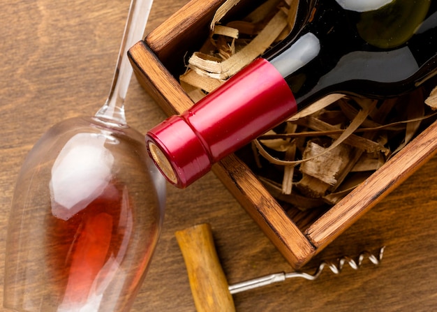 Foto gratuita botella de vino de primer plano y vaso con sacacorchos