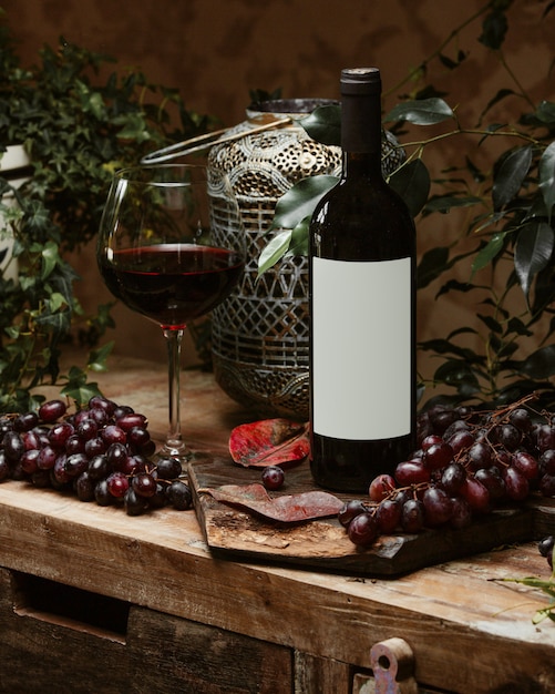 botella de vino tinto y una copa de vino tinto en estilo rústico