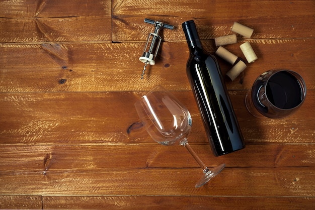Foto gratuita botella de vino tinto y copas con sacacorchos