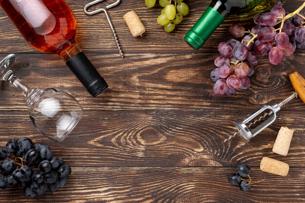 Botella de vino, uvas y copas en la mesa