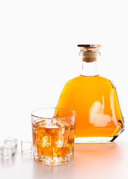 Botella de whisky vista frontal con vidrio
