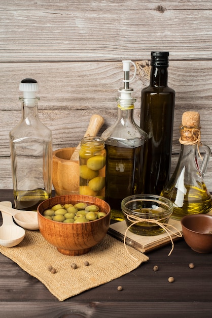 Botellas de aceite de oliva y aceitunas sobre la mesa