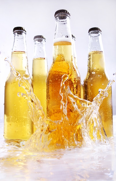 Foto gratuita botellas de cerveza con salpicaduras de agua.