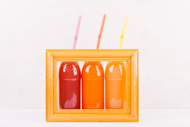 Botellas de jugo de colores en el marco