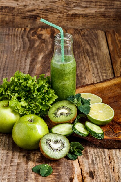 botellas con jugos de vegetales frescos en la mesa de madera