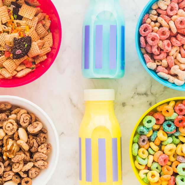 Foto gratuita botellas de leche con brillantes cuencos de cereales en la mesa