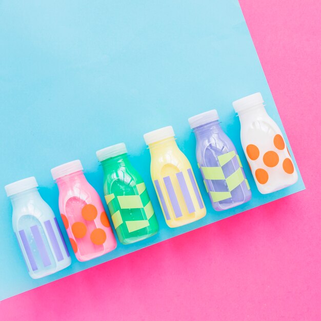 Botellas de leche coloridas en mesa brillante