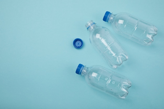 Botellas de plástico planas sobre fondo azul.