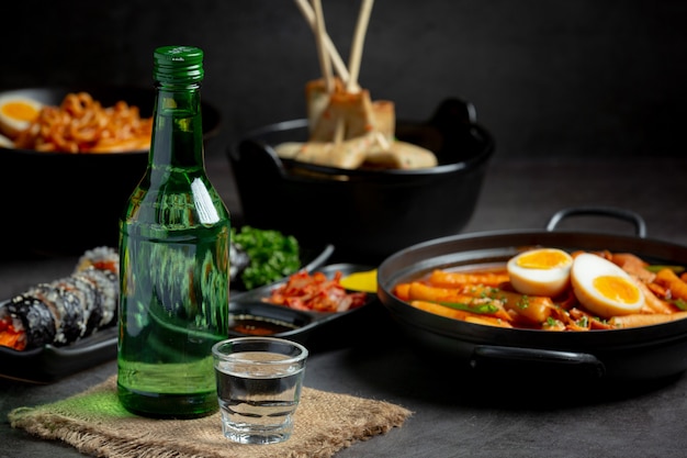 Botellas de soju y guarniciones coreanas en el menú.