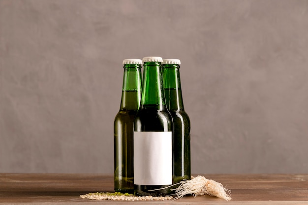 Botellas verdes en etiqueta blanca en mesa de madera