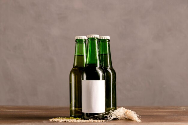 Botellas verdes en etiqueta blanca en mesa de madera