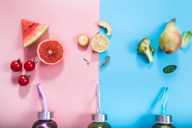 Botellas de vidrio con bebidas naturales en una pared de color.