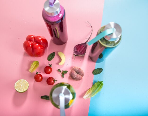 Botellas de vidrio con bebidas naturales sobre un fondo de color