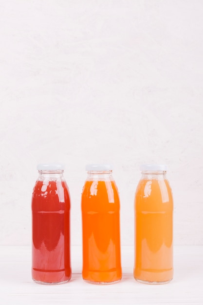 Foto gratuita botellas con zumo de frutas de colores.