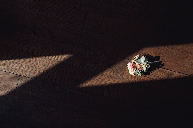 Boutonniere delicado hecho de rosas se encuentra en el alféizar de la ventana