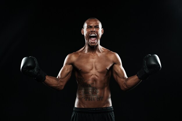 Boxeador afroamericano celebrando su victoria con los brazos levantados