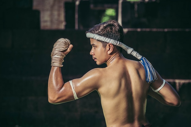 Foto gratuita un boxeador le ató una cuerda en la mano y realizó una pelea, las artes marciales del muay thai.