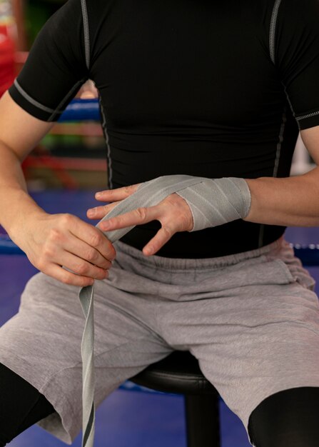 Boxeador envolviendo sus manos con protección antes del entrenamiento