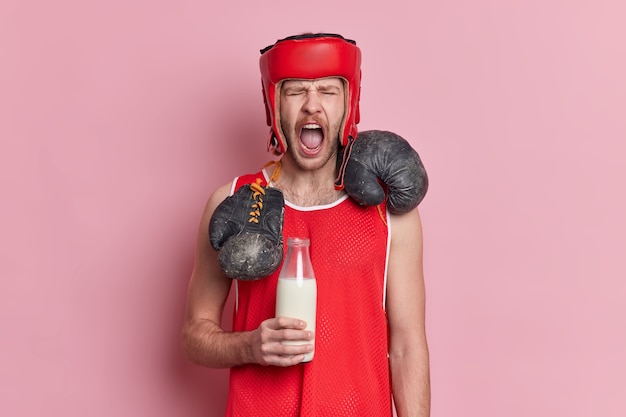 Foto gratuita el boxeador de hombre emocional en traje deportivo sostiene una botella de leche mantiene la dieta de proteínas obtiene vitaminas para los músculos exclama en voz alta.