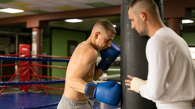Boxeador masculino con guantes de entrenamiento con hombre