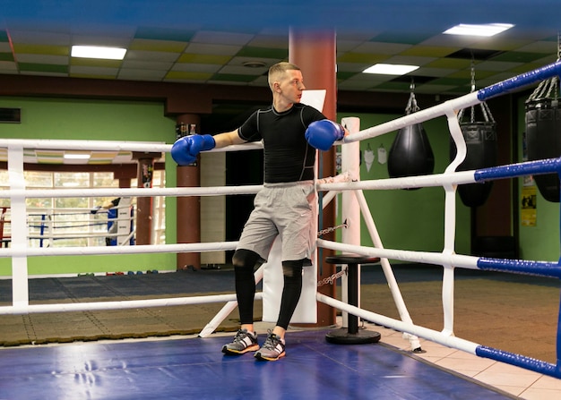 Boxeador masculino con guantes en el ring