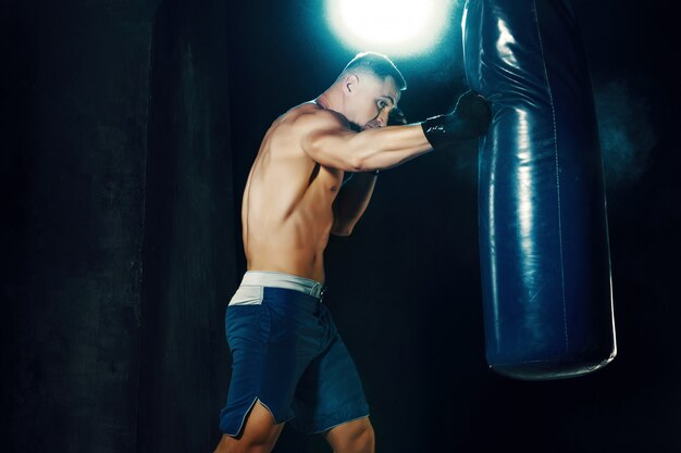 Boxeador masculino en saco de boxeo