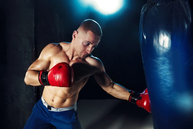 Boxeador masculino en saco de boxeo