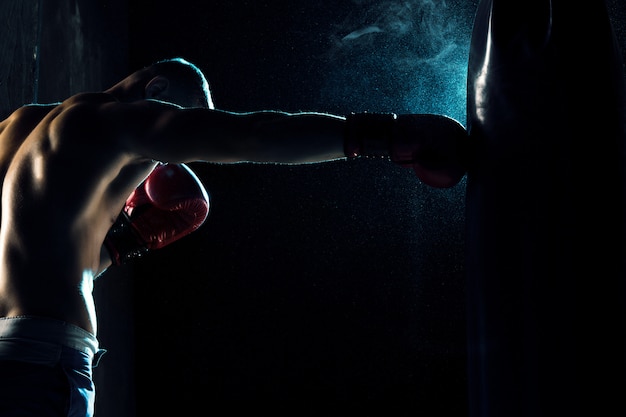 Boxeador masculino en saco de boxeo