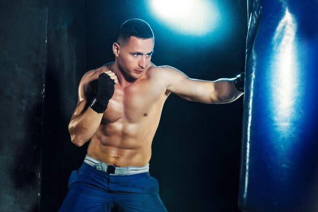 Boxeador masculino en saco de boxeo
