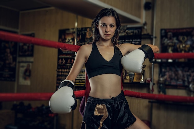 Foto gratuita la boxeadora atractiva está lista para pelear mientras está de pie en su esquina en el ring.