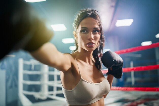 Boxeadora mostrando éxito en guantes de boxeo.