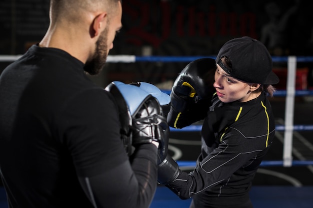 Foto gratuita boxeadora en el ring entrenando con guantes protectores