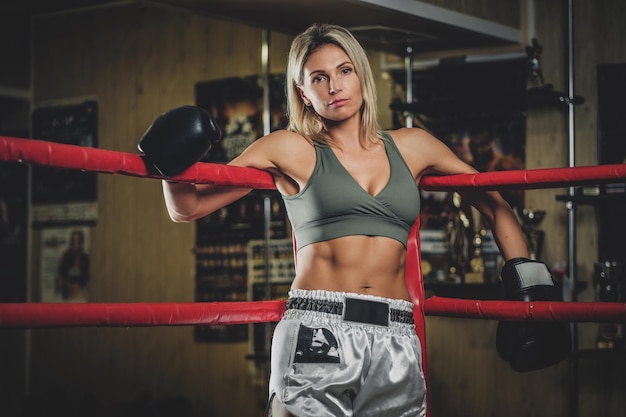 Foto gratuita una boxeadora rubia seria está lista para pelear, está parada en su esquina del ring.