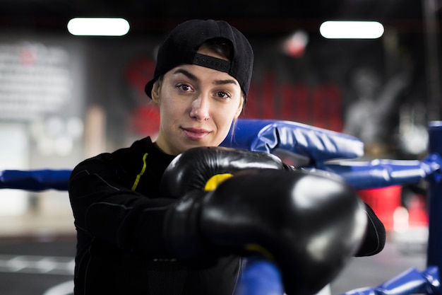 Boxeadora sonriendo y posando en el ring con guantes protectores