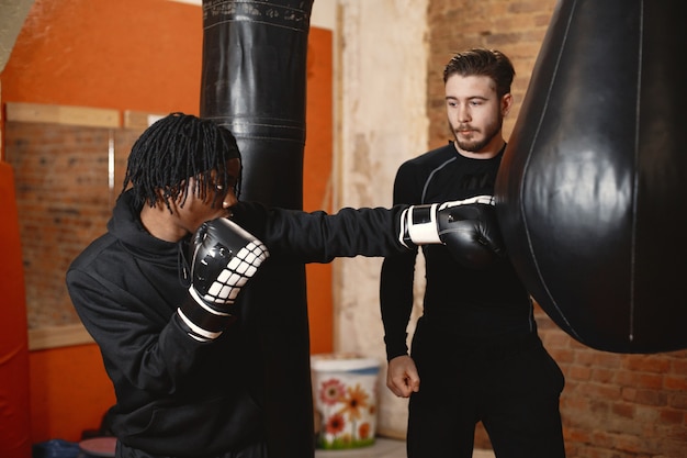 Boxeo de hombre deportivo africano. Entrenamiento de personas mixtas.