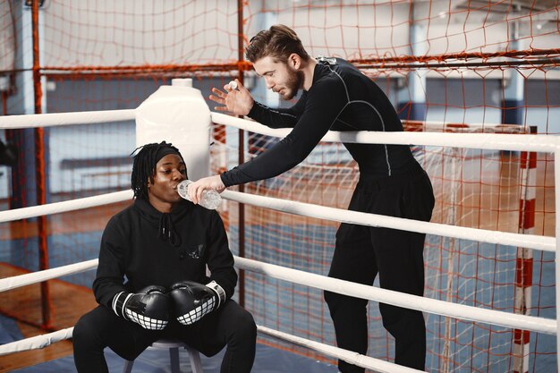 Boxeo de hombre deportivo africano. Entrenamiento de personas mixtas.