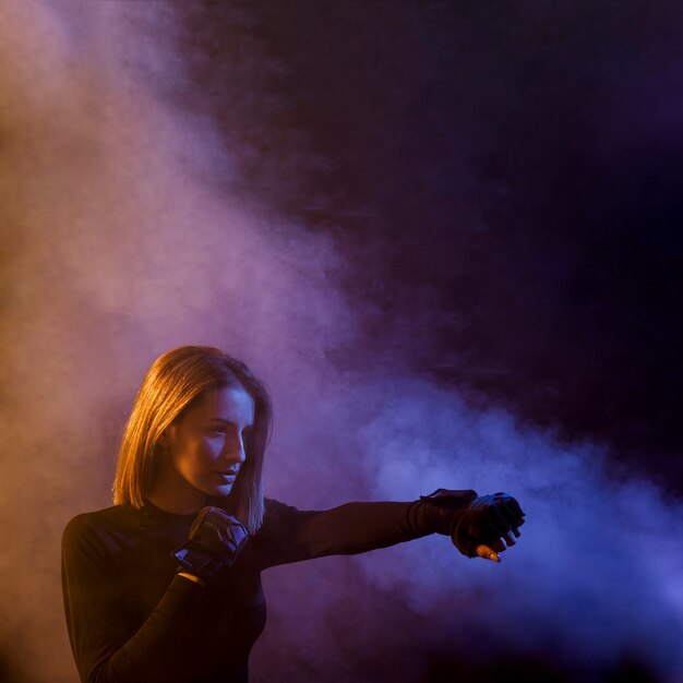 Boxeo mujer posando en el humo