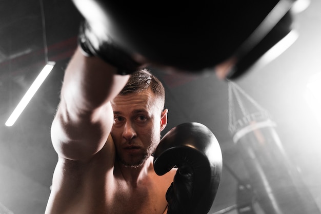 Boxer de ángulo bajo con guantes negros de entrenamiento