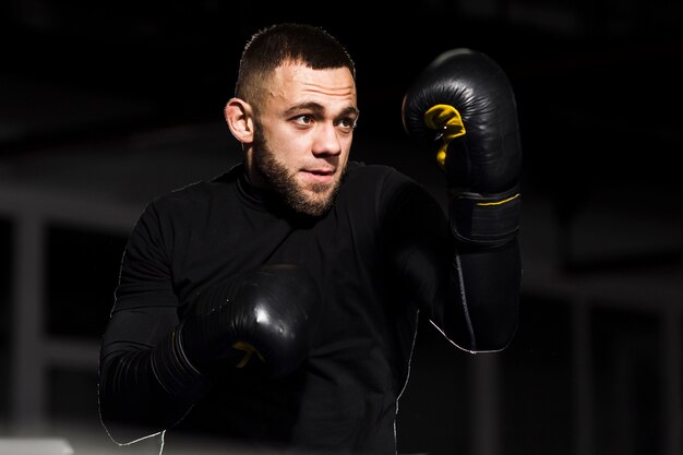 Boxer hombre posando en guantes protectores