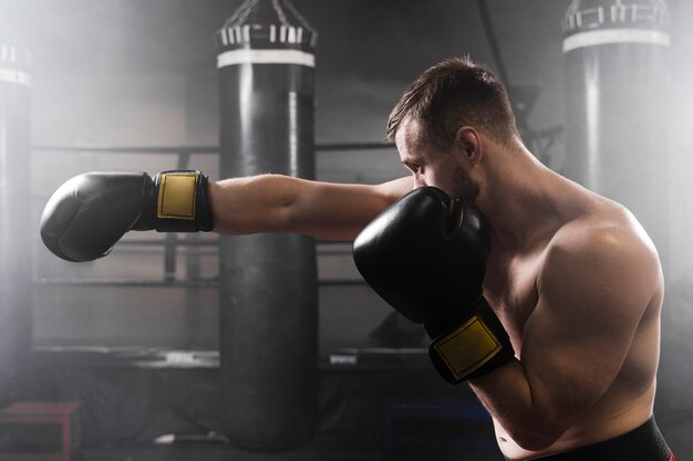 Boxer lateral con guantes negros de entrenamiento