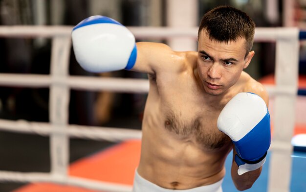 Boxer masculino sin camisa practicando en el ring