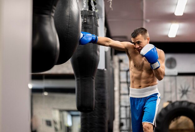Boxer masculino entrenando con guantes protectores