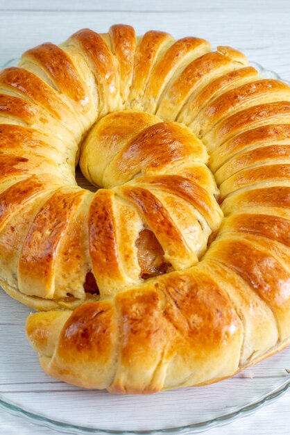 Brazalete de pastelería deliciosa horneada formada dentro de la placa de vidrio en el escritorio blanco, pastelería hornear galletas dulces