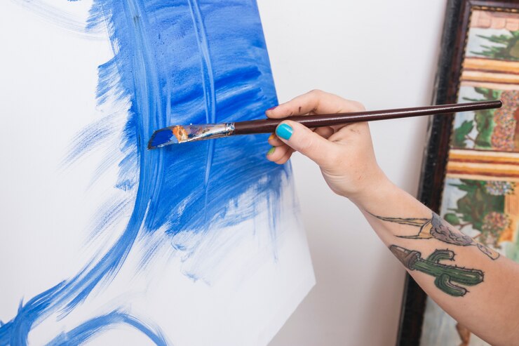 Foto gratuito brazo de artista tatuado de la cosecha con pincel y pintura