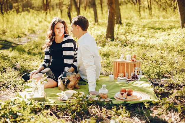 brillante y feliz mujer embarazada sentada en el parque con su marido