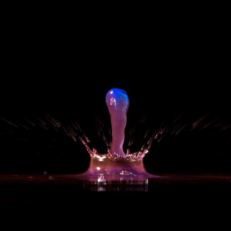 Foto gratuito brillante gota salpicaduras en negro