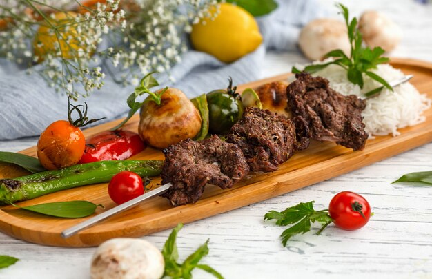 Brocheta de carne con verduras y arroz hervido.