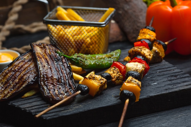 Brocheta de pollo con papas fritas y verduras