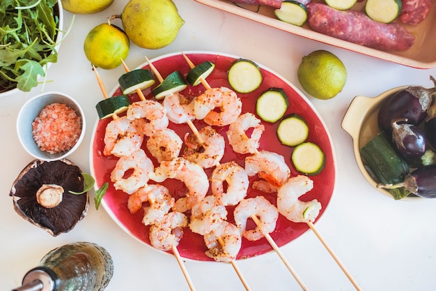 Foto gratuita brochetas de camarones servidos con verduras y frutas