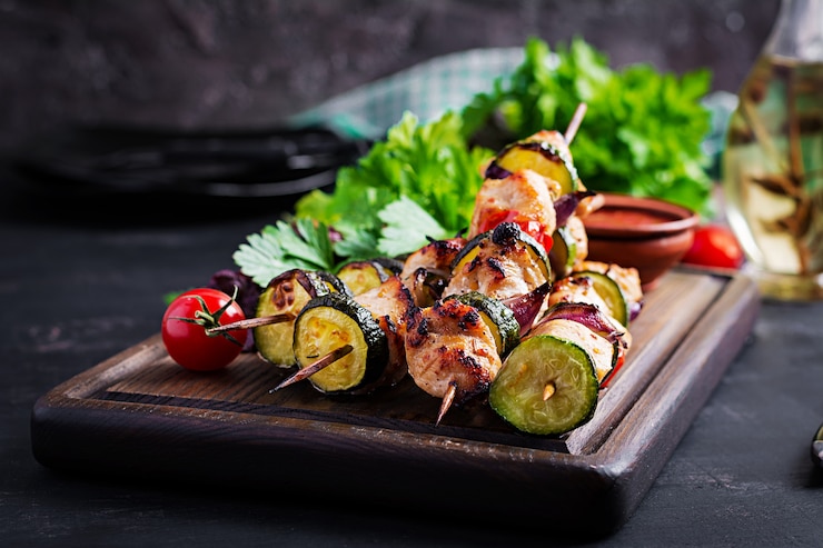 Foto gratuito brochetas de carne a la parrilla, shish kebab de pollo con calabacín, tomate y cebolla roja